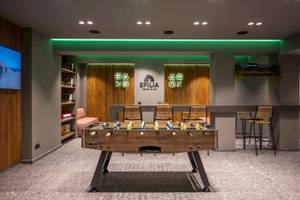 Arminda Hotel & Spa Spilia Teens Club mit Tischfußball, Holztüren und grüner Beleuchtung.