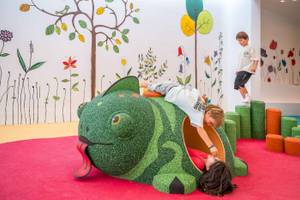 Kinder spielen in einem grünen, fischförmigen Spielbereich im Arminda Hotel & Spa.