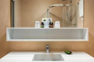 Badezimmer im Corissia Beach Hotel mit Dusche und Waschbecken.