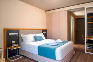 Innenansicht eines Zimmers im Corissia Beach Hotel mit Bett, Nachttischen und Schrank