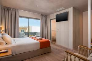 Innenansicht eines Doppelzimmers im Corissia Beach Hotel mit Bett, Fernseher und Balkon.