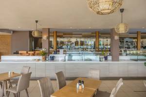 Innenansicht des Corissia Beach Hotel Restaurants mit Tischen, Stühlen und einer Theke.