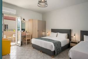 Doppelzimmer im Corissia Beach Hotel mit zwei Betten, Schreibtisch und Terrassenzugang.