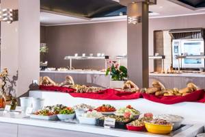Buffetmahlzeit im Corissia Beach Hotel mit verschiedenen Gerichten und Salaten.