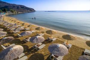 Luftaufnahme des Corissia Beach Hotels mit vielen Liegestühlen und Sonnenschirmen am Strand