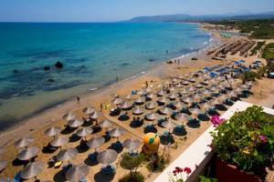 Luftaufnahme des Corissia Beach Hotels mit Sonnenterrasse und vielen Sonnenschirmen am Strand
