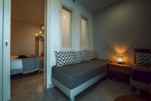 Schlafzimmer im Eliros Mare Hotel mit Sofabett, Nachttisch und Lampe.