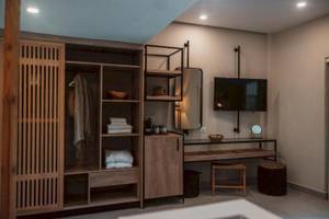 Innenansicht eines Zimmers im Eliros Mare Hotel mit Kleiderschrank, Fernseher und Schreibtisch.