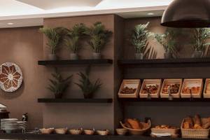 Frühstücksbuffet im Eliros Mare Hotel mit Brotkörben und Pflanzen.