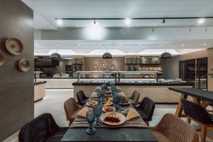 Innenansicht des Restaurants im Eliros Mare Hotel mit gedecktem Tisch und Büffet.
