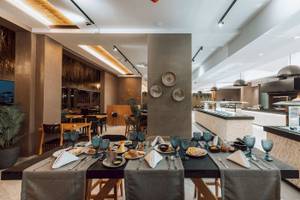 Frühstücksbuffet im Eliros Mare Hotel mit verschiedenen Gerichten und Geschirr.