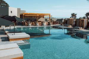 Außenbereich des Eliros Mare Hotels mit Pool, Lounge-Bereich und Bar.