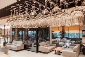 Loungebereich des Eliros Mare Hotels mit hängenden Weingläsern und Sofas.