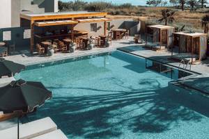 Außenbereich des Eliros Mare Hotels mit Pool, Bar und Sonnenliegen.