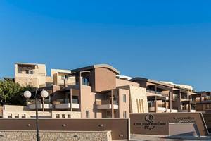 Haupteingang des Cretan Dream Resort & Spa mit mehreren Stockwerken und einem Logo