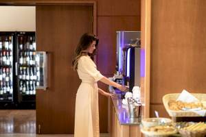 Frau am Kaffeeautomaten im Hotel Cretan Dream Resort & Spa