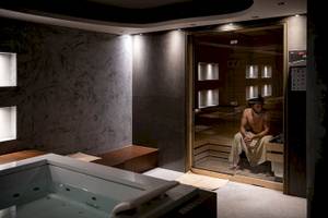 Ein Saunabereich im Cretan Dream Resort & Spa mit einem Mann, der in der Sauna sitzt.