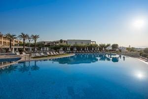 Außenpoolbereich des Cretan Dream Resort & Spa mit Sonnenliegen und Palmen