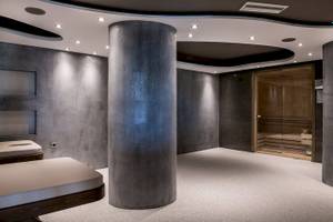 Saunabereich des Cretan Dream Resort & Spa mit grauen Wänden, einem zentralen Säulenelement und einem Holzsauna.