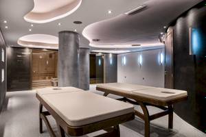Massageraum im Cretan Dream Resort & Spa mit zwei Massagetischen und einer Sauna.