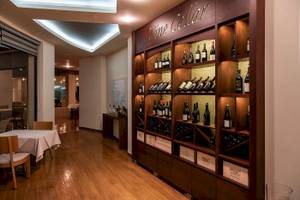 Ein Weinkeller im Cretan Dream Resort & Spa mit Flaschen und einem Tisch.