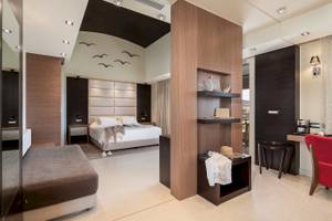 Innenansicht eines Schlafzimmers im Cretan Dream Resort & Spa mit einem Bett, Nachttischen und einer gemütlichen Atmosphäre.