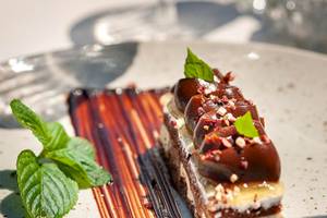 Stück Nachtisch im Cretan Dream Resort & Spa mit Schokoglasur und Minzblättern.