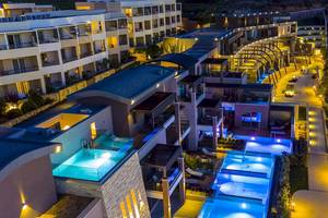Luftaufnahme des Cretan Dream Resort & Spa bei Nacht mit beleuchteten Gebäuden und Swimmingpools.