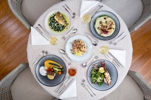 Foto von mehreren Tellern mit Gerichten auf einem Tisch im Cretan Dream Resort & Spa.