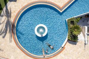 Luftaufnahme des Schwimmbeckens im Cretan Dream Resort & Spa mit drei Personen im Wasser.