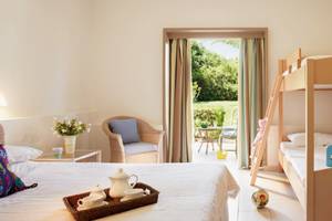 Doppelzimmer im Grecotel Meli Palace mit Doppelstockbett, Balkon und Gartenblick.