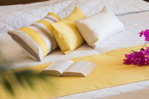 Hotelbett mit Kissen und Büchern von Chrissi Amoudia