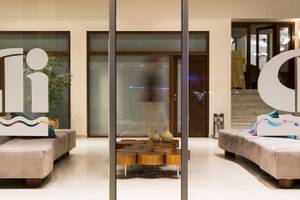 Lobby des Chrissi Amoudia Hotels mit modernen Möbeln und einem zentralen Tisch.