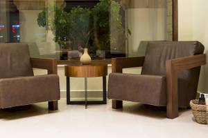 Loungebereich im Chrissi Amoudia Hotel mit zwei Ledersesseln und einem Tisch.
