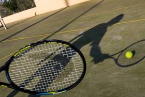 Tennisschläger mit Tennisball auf einem Tennisplatz.