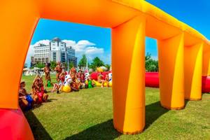 Kinder im Melas Lara Hotel spielen auf einer großen aufblasbaren Rutsche im Freien.