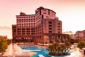 Melas Lara Hotel mit Swimmingpool und Palmen bei Sonnenuntergang