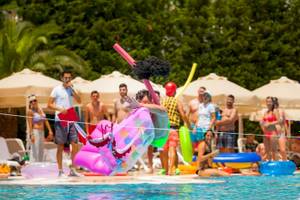 Pool-Party-Animation im Melas Lara Hotel mit einem Mann, der über eine aufblasbare Matratze springt.