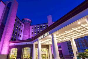 Melas Lara Hotel nachts mit lila Beleuchtung und hellem Eingangsbereich.