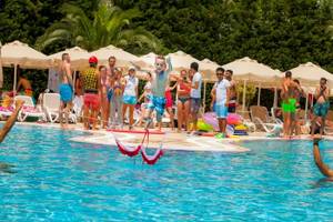 Im Melas Lara Hotel springen Kinder über Hüpfschlingen im Schwimmbad.