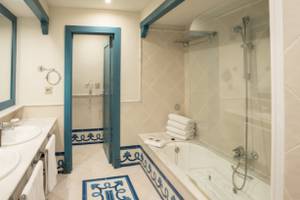 Badezimmer im LIVVO Volcan Lanzarote Hotel mit Badewanne und blauen Fliesen.