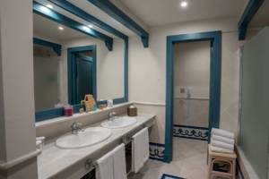 Badezimmer im LIVVO Volcan Lanzarote Hotel mit zwei Waschbecken, Spiegel, Badewanne und Dusche.