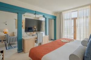 Innenansicht eines Zimmers im LIVVO Volcan Lanzarote Hotel mit einem großen Bett, Fernseher und Schreibtisch.