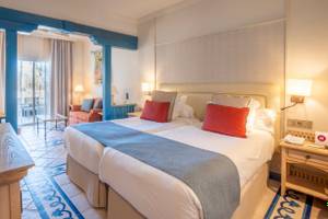 Doppelzimmer im LIVVO Volcan Lanzarote mit zwei Betten, einem Balkon und modernen Möbeln.