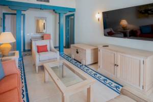 Wohnzimmer-Innenansicht im LIVVO Volcan Lanzarote Hotel mit Sofa, Couchtisch, Fernseher und Lampe.