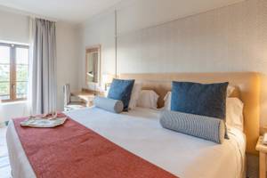 Ein elegantes Hotelzimmer im LIVVO Volcan Lanzarote mit einem Bett, Kissen und einem Schreibtisch.