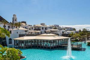 Livvo Volcan Lanzarote Hotel mit Pool und Gebäuden im Hintergrund