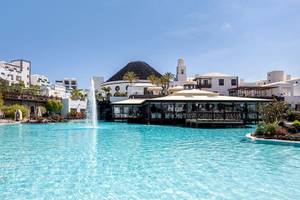 Außenpool des LIVVO Volcan Lanzarote Hotels mit weißen Gebäuden im Hintergrund.