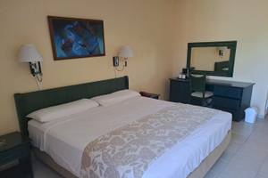 Hotelzimmer im Muthu Playa Varadero mit Doppelbett, Nachttischen und Dekor.