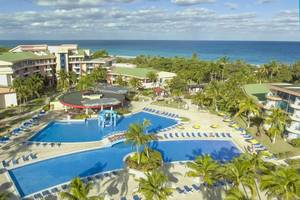 Luftaufnahme des Muthu Playa Varadero Hotels mit großen Swimmingpools und Sonnenliegen.